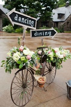 a bicycle with flowers and signs attached to it's front wheel that says dancing