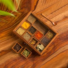 a wooden box filled with spices on top of a table