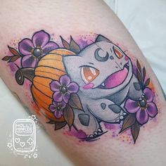 a tattoo with an image of a rhino and flowers on it's side thigh