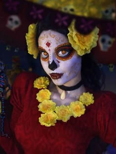 a woman with white makeup and yellow flowers in her hair is dressed as a skeleton