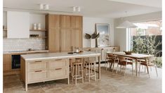 a large kitchen with lots of counter space and wooden cabinetry, along with an island in the middle