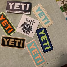 several stickers that are laying on top of a piece of cloth with the word yet