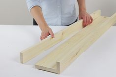 a person is cutting wood with a pair of scissors on a white counter top,