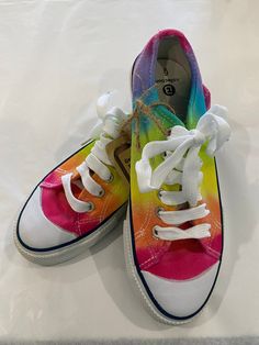 Step up your shoe game with these vibrant, eye-catching rainbow hand-dyed sneakers! These shoes are a burst of fun and colour, the bright shades blend seamlessly together to create a stunning kaleidoscope effect that's bound to turn heads (and heels). Each pair is hand-painted with love and care, making them one-of-a-kind. So why settle for boring shoes when you can strut your stuff in these dazzling kicks? The ultimate guilt free pick-me-up. Rainbow Low-top Custom Sneakers For Streetwear, Satin Rainbow Shoelaces, Casual Rainbow Synthetic Sneakers, Casual Custom Rainbow Lace-up Sneakers, Multicolor Hand Painted Slip-on Sneakers, Pride Shoes, Rainbow Sneakers, Skater Shoes, Rainbow Shoes