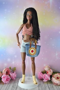 a barbie doll holding a purse on top of a table