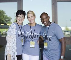 three people standing next to each other wearing t - shirts with the words home on them