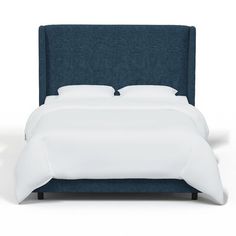 a bed with white sheets and blue headboard