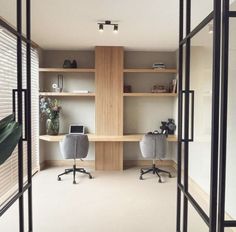 an office with glass walls and wooden shelves