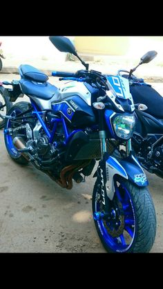 two motorcycles parked next to each other in a parking lot with no one around them