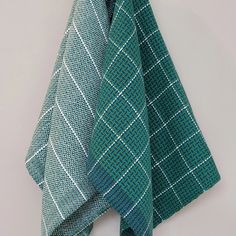 two green and white ties hanging on a wall