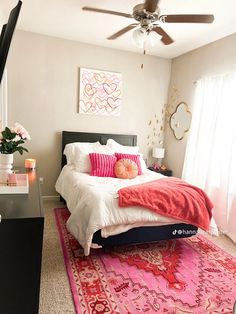 a bedroom with a bed, rug and ceiling fan