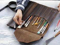 The brush case is made of genuine leather and will hold all that you need. It's a perfect case to keep pens, pencils, and brushes in one place. The artist roll is made of genuine leather, we offer it in 8 colors. Also, you can add personalization. Simple, well-made, and personalized pencil roll case - perfect birthday gift or lovely Gift for a painter or any art creator! ♦ ♦ ♦ ♦ ♦ ♦ ♦ ♦ ♦ ♦ ♦ ♦ ♦ ♦ ♦ ♦ ♦ ♦ All our products are made to order with great care and special attention in our workshop. Artistic Pencil Case For Personal Use, Modern Leather Pencil Case Gift, Artist Pencil Case, Roll Pencil Case, Tool Roll Bag, Brown Leather Pencil Case With Pen Holders, Leather Pencil Roll, Modern Leather Pencil Case With Pen Slots, Pencil Roll