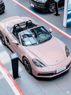 a pink sports car parked in a showroom