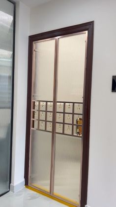 an open glass door in the corner of a room with white walls and tile flooring