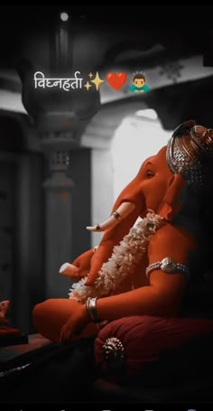 an elephant statue sitting on top of a red couch next to a wall with the words happy diwali written above it