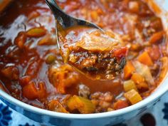 a spoon full of soup with meat and vegetables