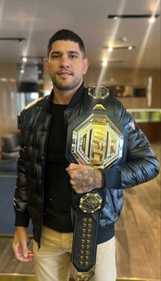 a man in black jacket holding up a wrestling belt