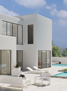 a modern house with white furniture next to a swimming pool