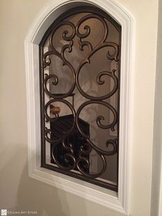 a decorative window in the corner of a wall with an iron grill on it's side