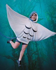 a woman in a costume that looks like a giant fish is floating through the air