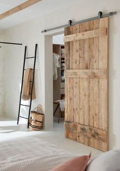 an open wooden door in a white bedroom