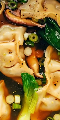 pasta and vegetables are being cooked in a broth with some seasoning on top