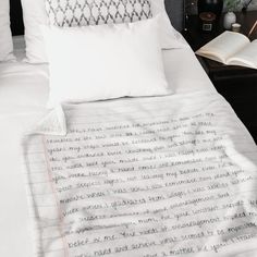 an unmade bed with two books on top of it and a lamp next to it