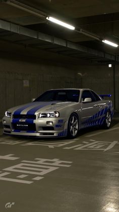 a silver and blue car parked in a parking garage