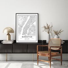 a black and white poster sitting on top of a wooden shelf next to a chair