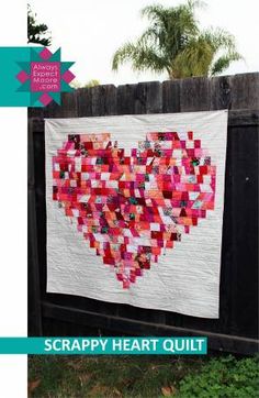 a heart quilt hanging on a fence with the words scrappy heart quilt over it