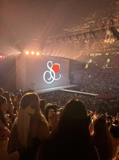 a large group of people at a concert in front of a screen with the amp logo on it