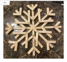 a snowflake made out of wooden sticks sitting on top of a marble counter