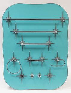 a blue glass display with multiple pairs of metal spikes and rings on the bottom half of it