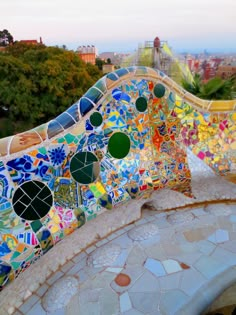 colorful tiles on the side of a building with trees and buildings in the back ground