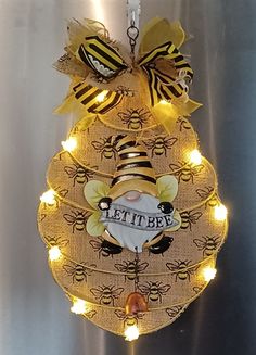 a light up bee decoration hanging from a wall