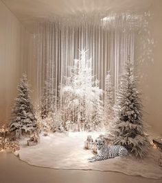 a room filled with snow covered trees next to a white christmas tree and other decorations