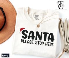 Get into the festive spirit with this funny Christmas T-shirt featuring "Santa Please Stop Here". Perfect for holiday parties, cozy gatherings, or adding cheer to your day. This playful tee makes a great gift for friends and family or a fun addition to your own collection. Celebrate the holiday season in style! **Designed by ComforTeeStudio** **Ships from Texas Shorter shipping distances are kinder to the planet. **About This Item** - **Size This is a standard unisex Comfort Colors t-shirt. - ** Santa Graphic, Funny Christmas Tshirts, Please Stop, Holiday Shirt, Graphic Tee Shirt, Christmas T Shirt, Festive Holiday, Holiday Shirts, Graphic Tee Shirts