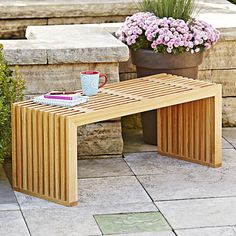 a wooden bench sitting next to a potted plant