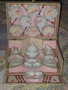 a pink and white porcelain tea set in a box