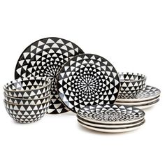 black and white plates with designs on them are stacked in front of each other,