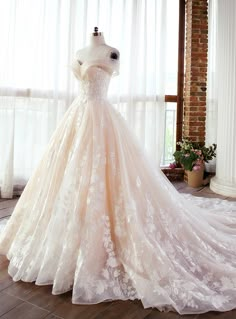 a wedding dress on display in front of a window