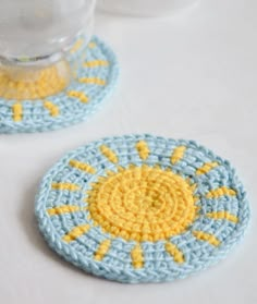 two crocheted coasters sitting on top of a table