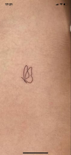 the back of a woman's stomach with a small heart tattoo on her left side