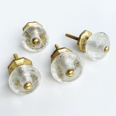 four glass knobs with gold accents on white surface