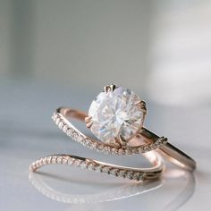 a close up of a diamond ring on a white surface with diamonds around the band