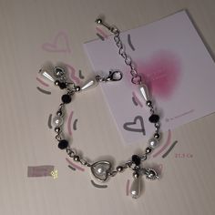 a silver bracelet with black and white beads on it next to a card that says i love you