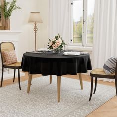 a dining room table with two chairs and a flower centerpiece