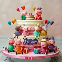 a birthday cake with peppa pig figurines on top and balloons in the air