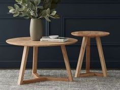 two wooden tables sitting on top of a rug next to a vase filled with flowers