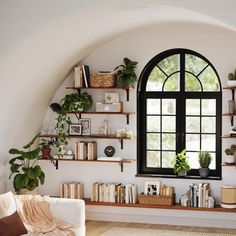 a living room filled with furniture and lots of plants on the wall next to a window